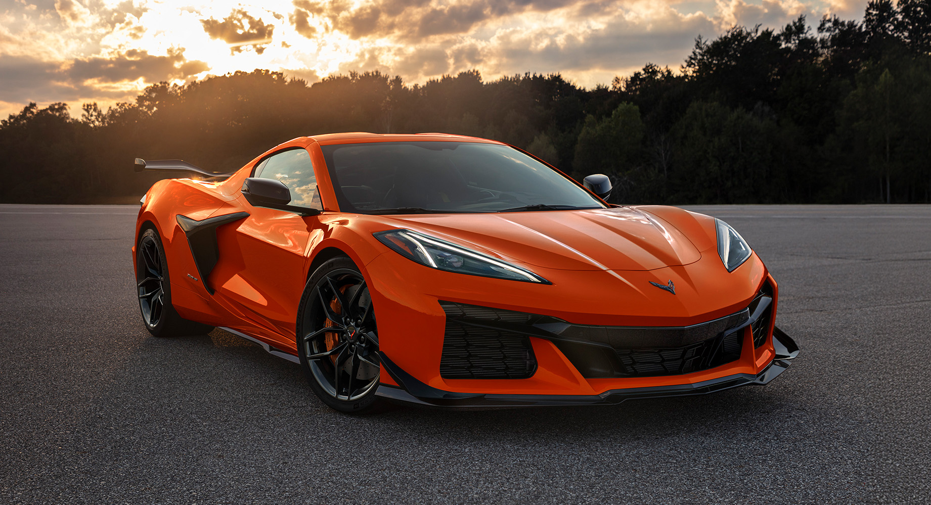 Vibrant orange Chevrolet Corvette in an asphalt lot at golden hour