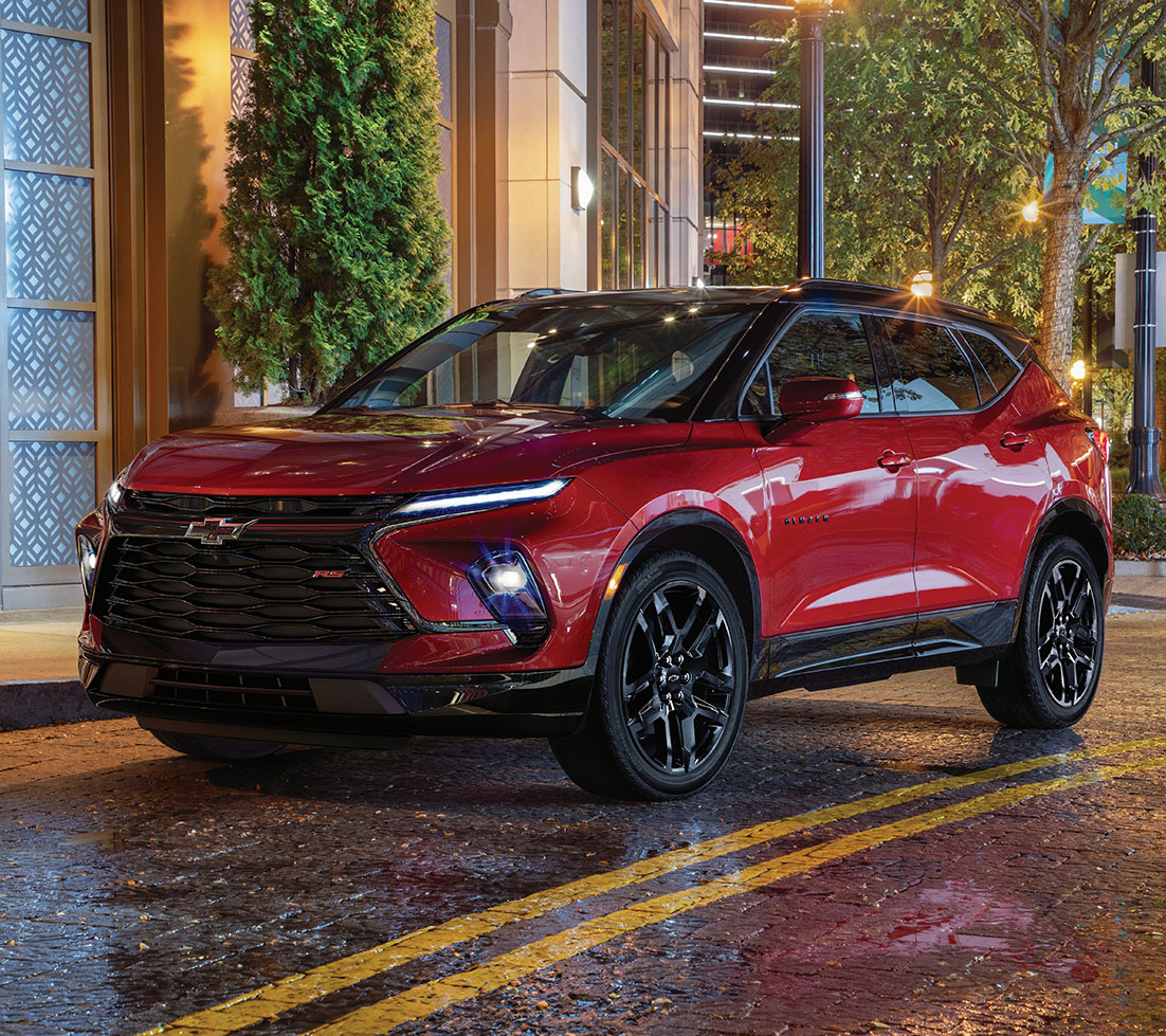 Sleek red Chevrolet Blazer on a wet urban street at night