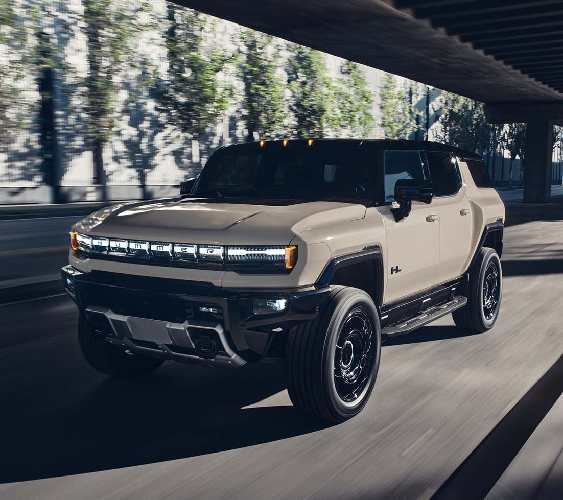Tan GMC HUMMER EV SUV in motion